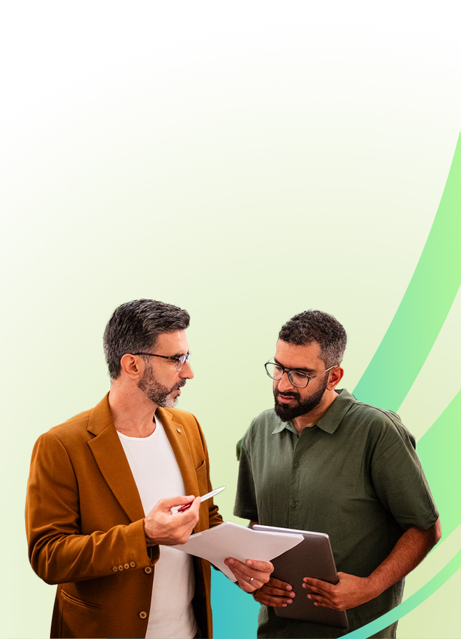 Two men stand discussing documents; one holds a clipboard and gestures with a pen, while the other holds a tablet. Both look focused, with a light green gradient background and abstract green curves behind them.