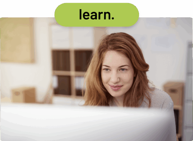 Eine Frau mit langen, hellbraunen Haaren blickt lächelnd auf einen Computerbildschirm. Über ihr ist ein grünes Oval mit der Aufschrift „Learn“ zu sehen. Im Hintergrund sind Regale und ein heller Raum zu sehen.