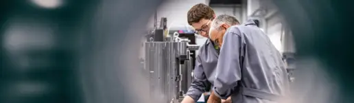 Zwei Arbeiter in einer Maschinenhalle