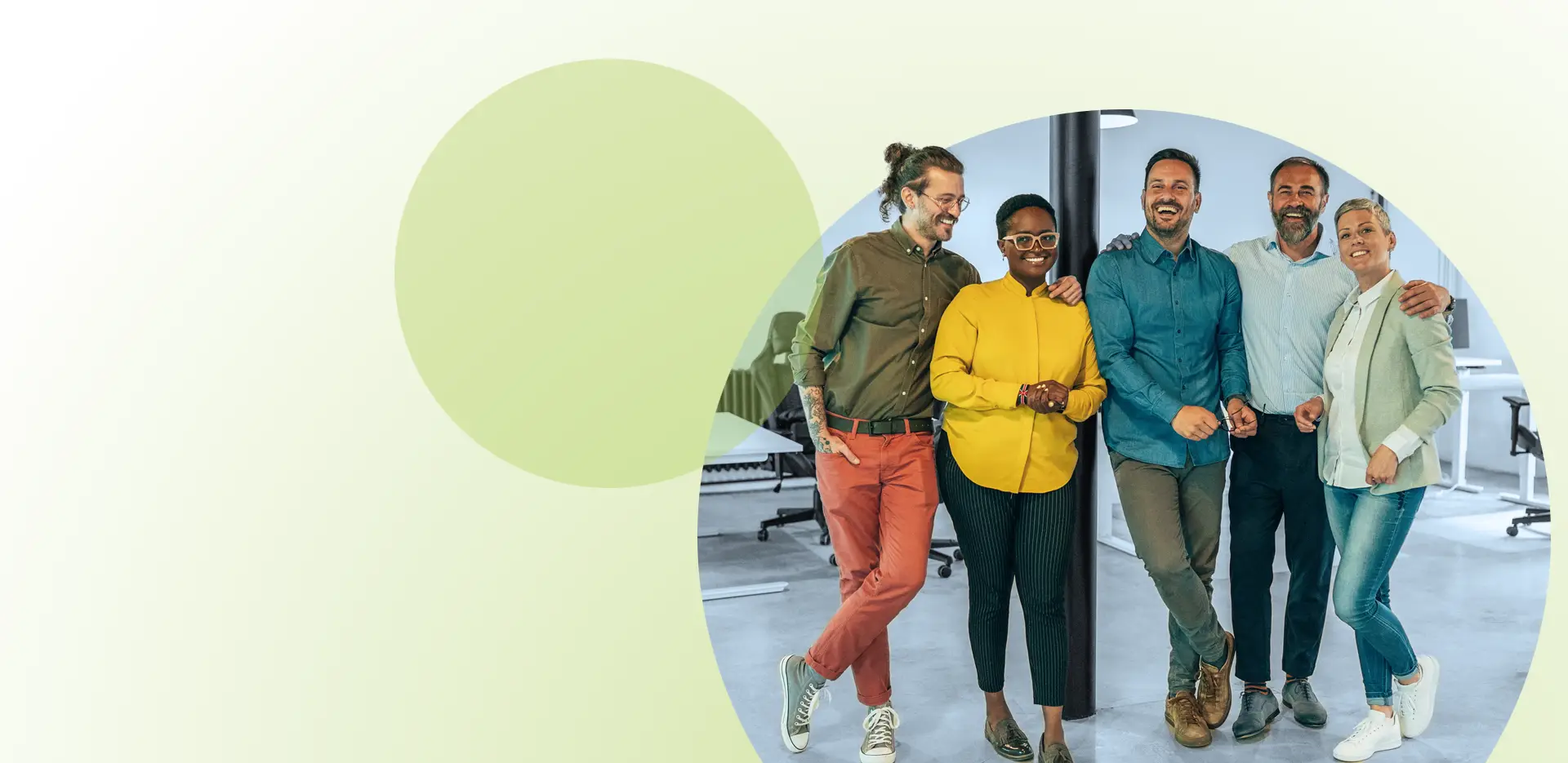 Fünf Menschen stehen gemeinsam in einem Büro, lächeln und posieren für ein Gruppenfoto – ein Bild, das den Geist der Teamentwicklung für Unternehmen perfekt einfängt. Der Hintergrund zeigt einen dezenten grünen Farbverlauf mit abstrakten Formen auf der linken Seite, was der professionellen Umgebung eine moderne Note verleiht.