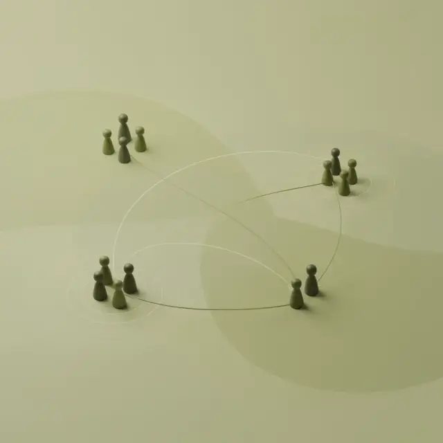 Vier Gruppen grüner Spielfiguren sind in Kreisen auf einer beigen Fläche angeordnet und durch geschwungene Linien miteinander verbunden, was an ein Netzwerk oder ein Kommunikationskonzept erinnert – eine ideale visuelle Metapher für das „Führungstraining für Führungskräfte“.